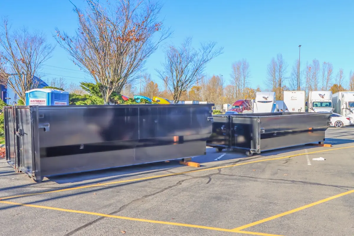 Professional dumpster rental service with roll-off container on residential driveway in McComb